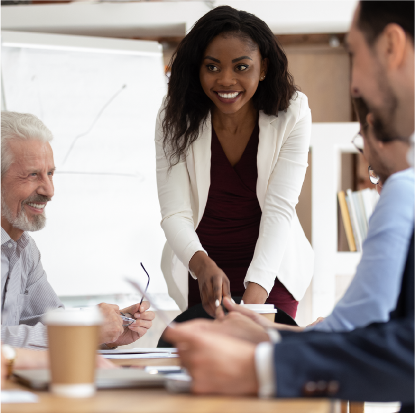 A female at the end of the table leading a business meeting.