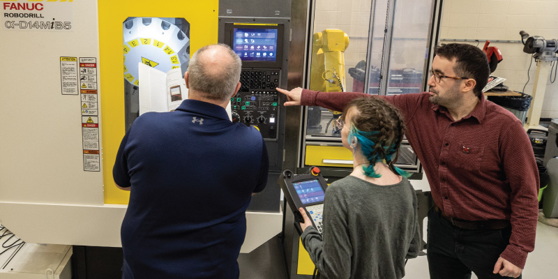 Professor showing a student the cnc machine.