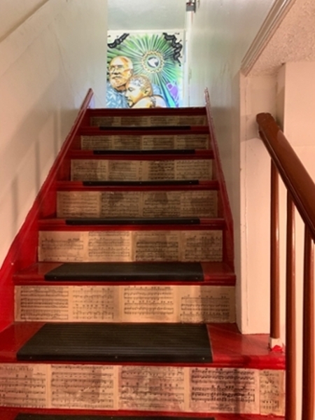 The staircase at The Fringe Coffee House with pages from books lining the bottom on the stairs.  
