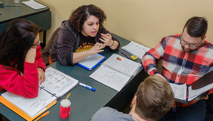 4 students working in a group around a table.