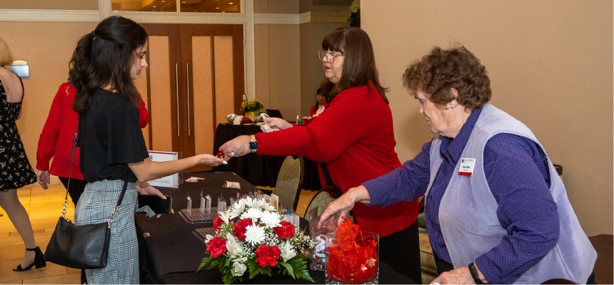 Alumni staff working at the Nursing Alumni dinner checking students in.