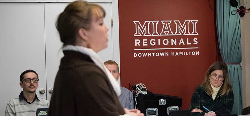 A woman speaking with the Miami Hamilton Downtown wordmark on the wall in the background. 