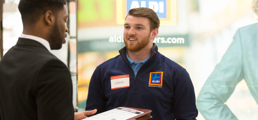 A employee from Aldi talking to a Miami University student.