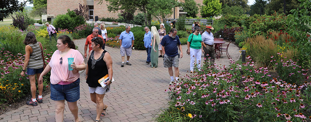  A group of people walking through the formal gardens.
