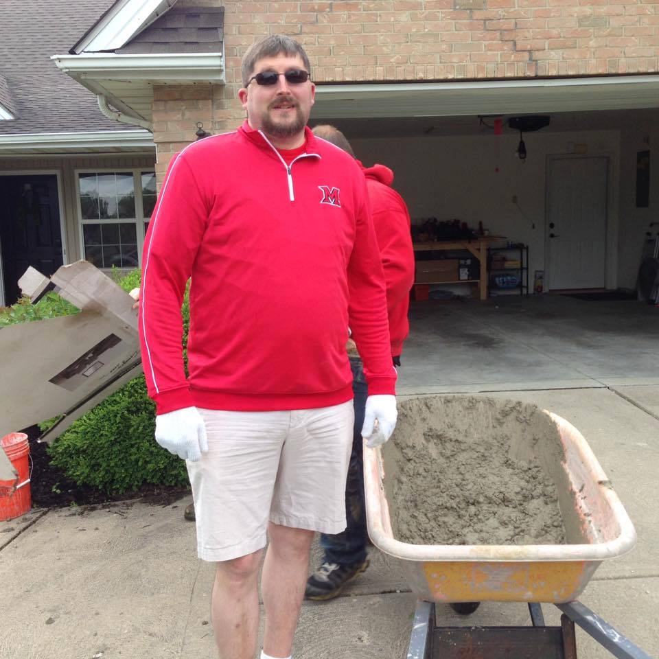 David Glock pictured working with cement to lay a sidewalk as part of the Caring Craftsmen.