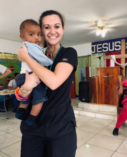 Alissa Smith holding a young boy at a clinic held inside a church in the community of Camalote