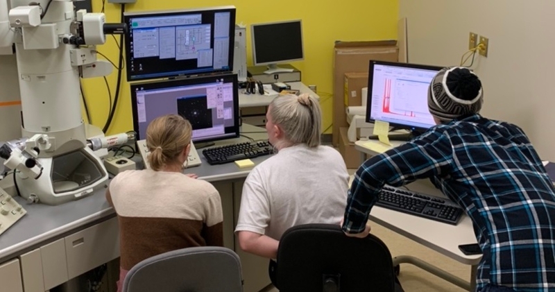 Grad student Sarah Wayman, Lauren Doepke, Carter Lindeman working on the transmission electron microscope