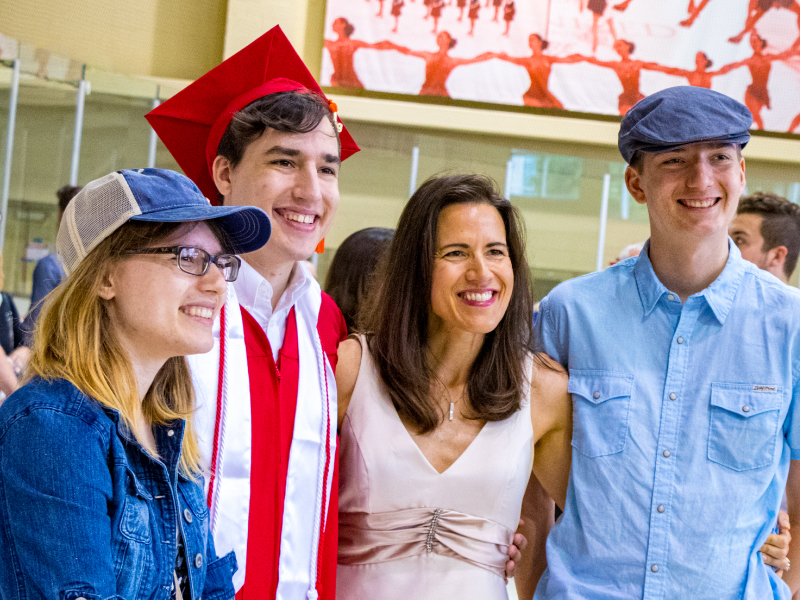 A graduate at commencement with his family.