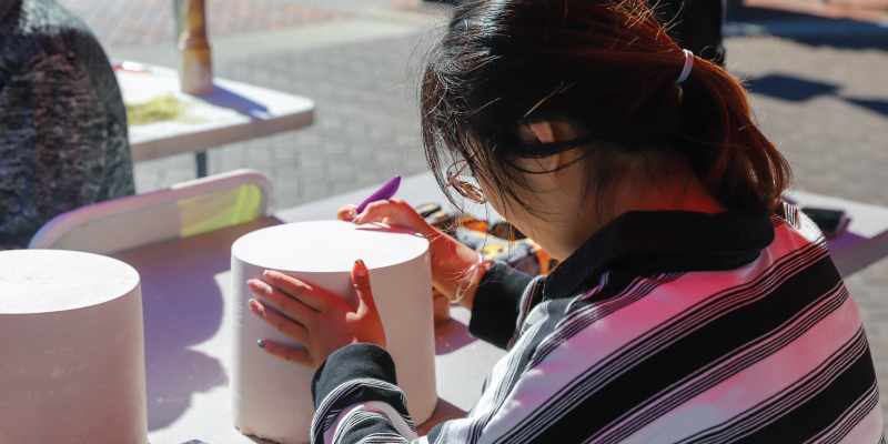 A student carving a piece of clay into a sculpture. 