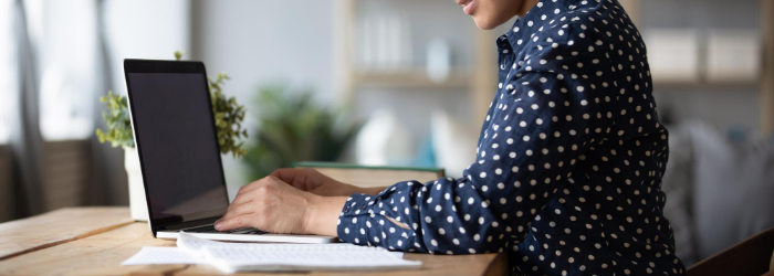 Person working at laptop with papers