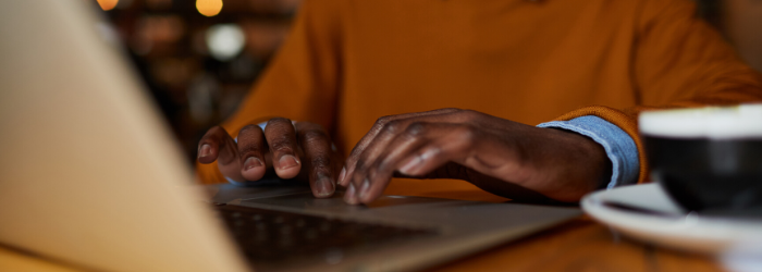 Person typing on laptop in coffee shop