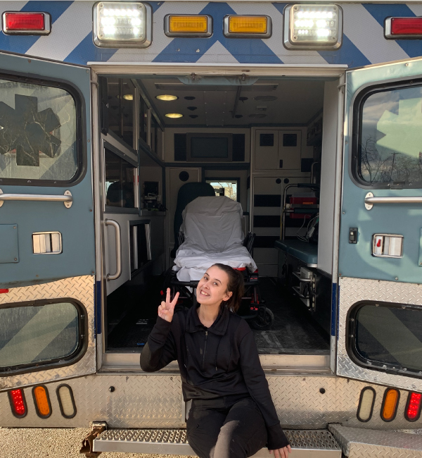 Kira Pierson sitting on the back on an ambulance.