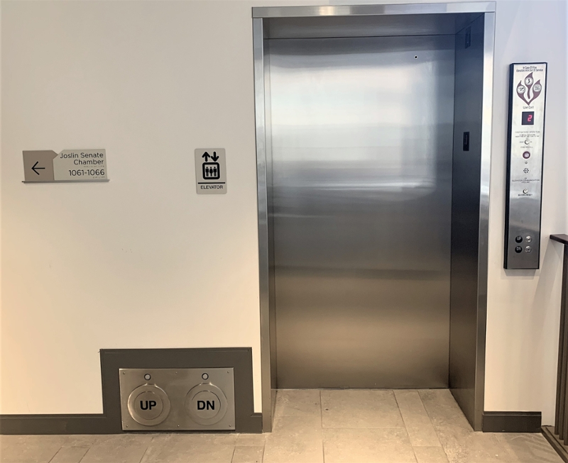Elevator entrance with access buttons near the floor reading Up and Down