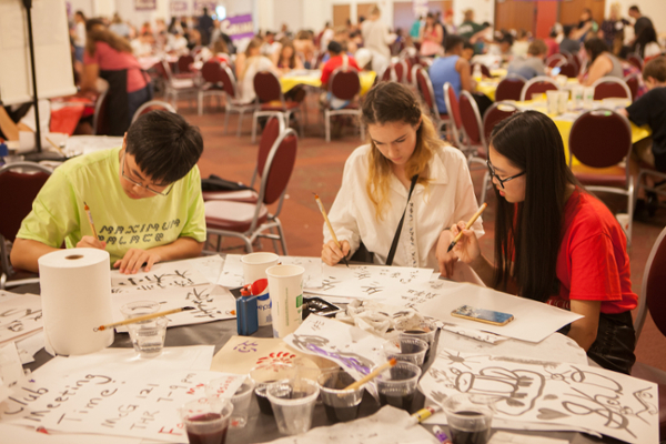 Tables across Armstrong Pavilion filled with students doing various arts and crafts at Art After Dark. 
