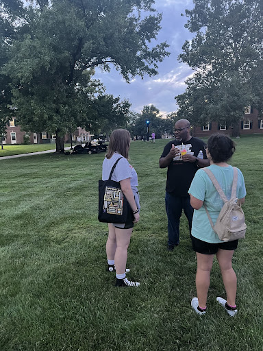 BaShaun Smith speaking to two students on Central Quad.