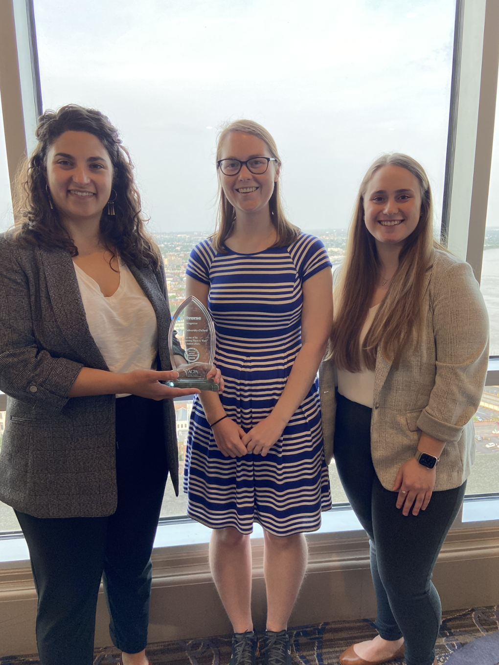 Kara Strass, Emily Cluen, and Kailey Costible at the ACPA event, holding the statue award.