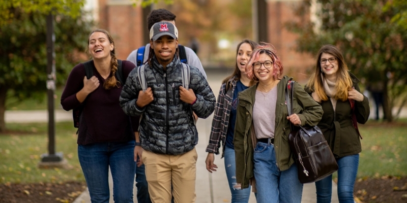group of students walking across academic quad. 