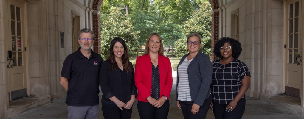  Tim Parsons, Gabby Dralle, Dean Kimberly Moore, Sherry Hampton Martin, and Jaymee Lewis Flenaugh, posing under the Upham Arch