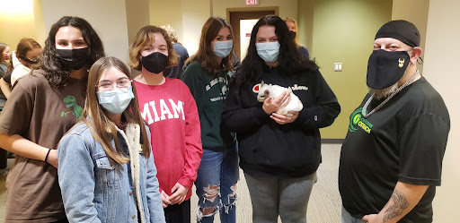 5 students in Hahne Hall, one holding a chinchilla, with a staff member from Cool Critters Outreach.