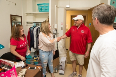  President Crawford shaking a new students hand in a residence hall room on Move In Day