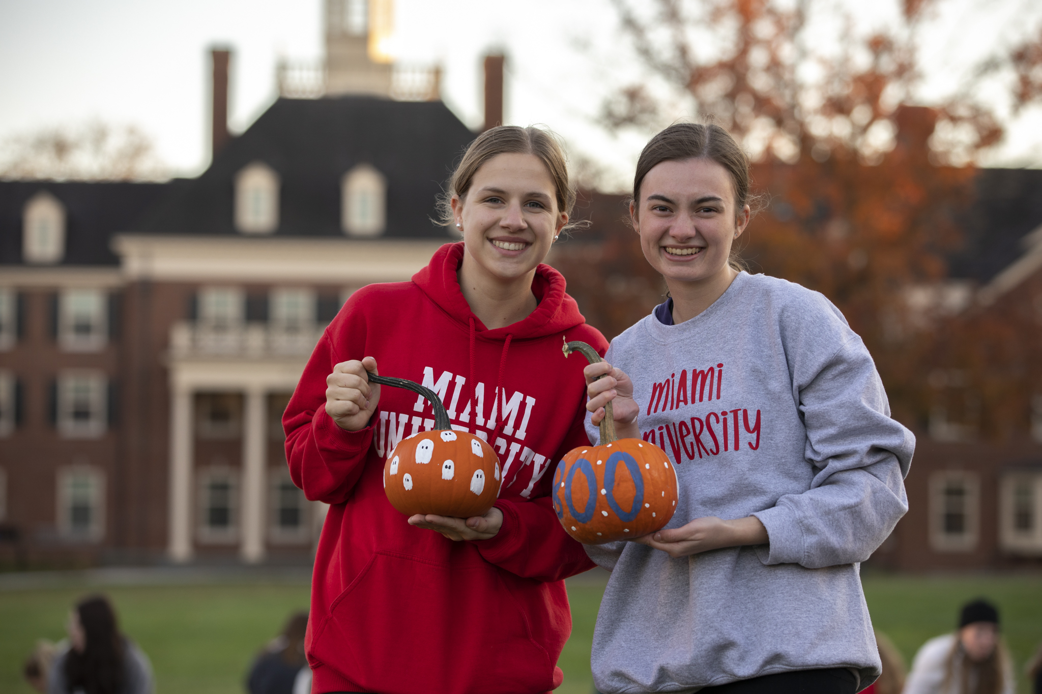 students holding painted pumpkins