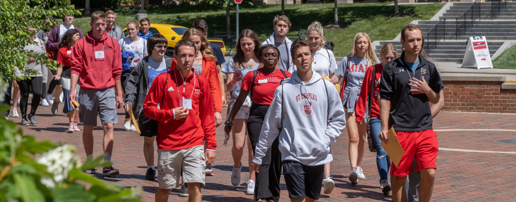 Large group of Miami students walking across campus at Orientation