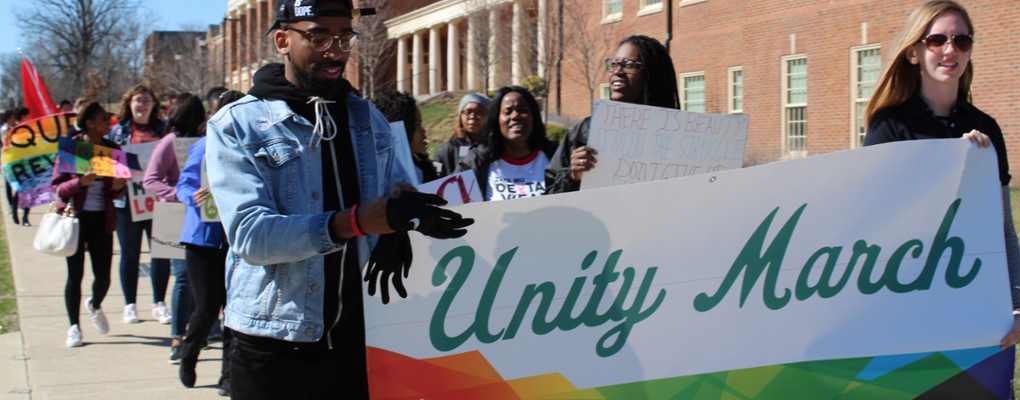 Two members of the Diversity Affairs Council leading Unity Day March while carrying Unity Day banner 