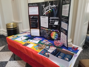 Table set up in Farmer School of Business with Spectrum tri-fold board, brochures, condoms, and more.
