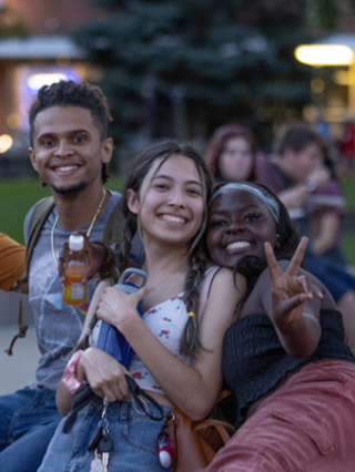 Diverse students in uptown Oxford smiling and posing at an outdoor festival.