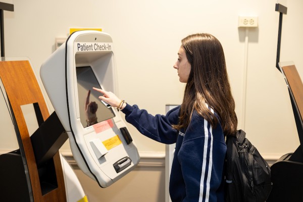 Student checking in for an appointment at the patient kiosk