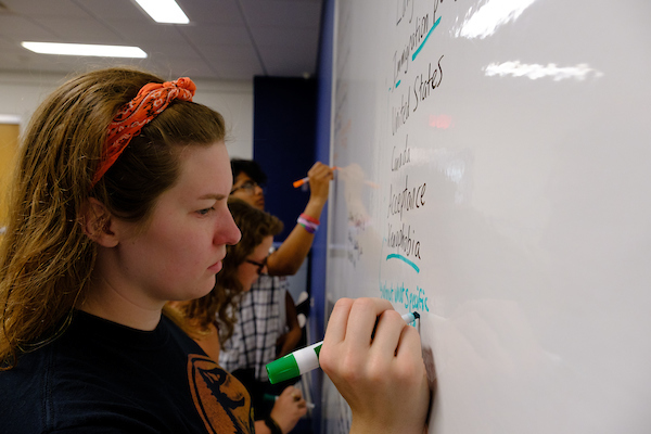 A student writing on a white board.