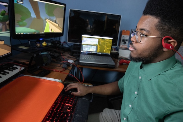 Student works on music composition project at keyboard