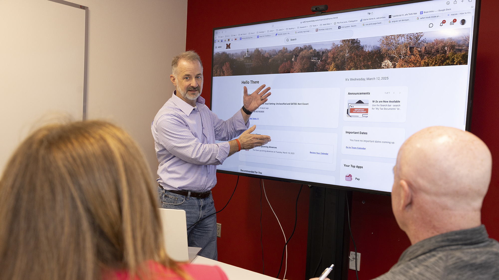 A staff member presents on Workday to two other staff members.